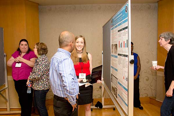 Graduate students and CAWS members Megan LaFollette (center) and Amy Robinson-Junker (left) discuss their posters with Symposium attendees.  