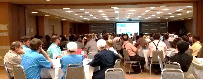 a full room listens to a presentation