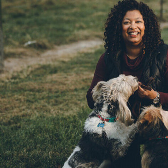 A photo of Dr. Croney outdoors, smiling, with a dog